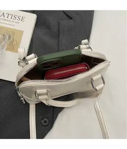 Vue de dessus de l'intérieur du sac crème avec un smartphone et un portefeuille rouge