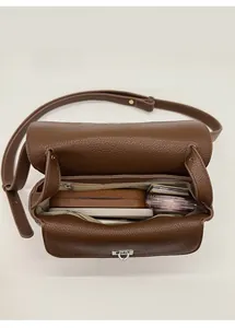 Interior view of small square crossbody bag showing storage capacity for phone and makeup