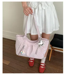 Pink polka dot tote bag detail with star charm and cute plush rabbit accessory