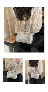 Detailed close-up of shell-shaped silver handbag featuring heart and key metal charms