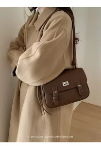 Close-up of retro dark brown lychee leather crossbody bag worn with a stylish khaki wool coat