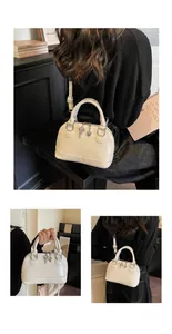 Detail of cream shell-shaped crossbody bag with heart charms and adjustable strap