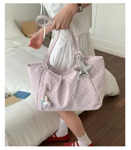 Pink polka dot shoulder tote bag detail view with cute star and rabbit plush pendants.