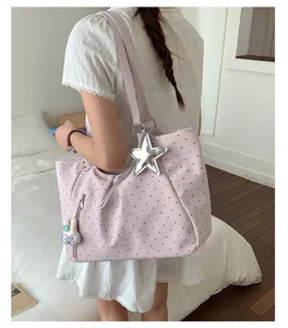 Large pink polka dot tote bag featuring silver star charm and cute rabbit pendant on model