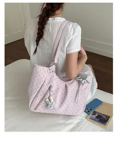 Pink polka dot tote bag detail view showing shoulder strap and cute bunny keychain accessory.