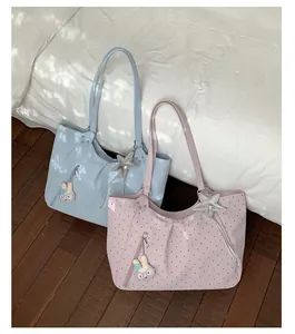 Detailed shot of cute polka dot tote bag with rabbit charm and front zipper pocket setup.