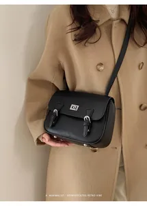 Detail of black lychee grain messenger bag styled with a minimalist retro vibe