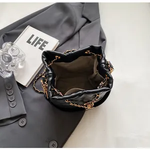 Top view of black quilted bucket bag showing beige lining and interior storage space