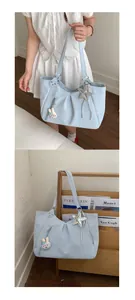 Detail view of the stylish blue polka dot tote bag, featuring cute charms and spacious design.