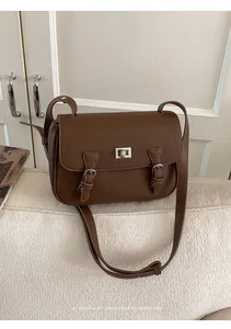 Detailed texture of dark brown lychee grain leather with silver metal twist lock closure