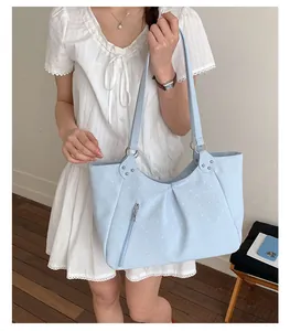 Detail of light blue polka dot tote bag with silver hardware and natural folds
