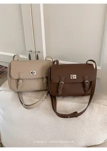Close-up of retro beige and brown leather satchel bags with silver metal turn-lock closures