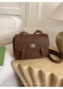 Close-up of brown lychee texture leather satchel with silver metal rotary lock