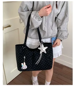 Black polka dot tote bag with star and rabbit charms lifestyle view