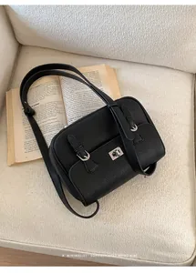 Macro view of black lychee grain leather handbag with silver metal swivel lock