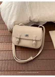 Detailed close-up of beige lychee grain leather crossbody bag with silver twist lock