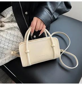 Détail du sac à main en cuir PU crème avec logo de la marque et poignée ronde chic