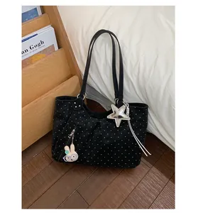 Close-up of black polka dot tote bag with star and bunny charms in a cozy lifestyle setting