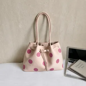 Dettaglio della borsa tote rosa chiaro a pois con trama in pelle e fibbia in metallo