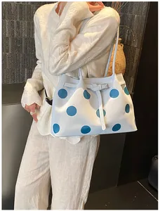 Dettaglio della grande borsa tote a pois con fibbia metallica e sottile tracolla chic