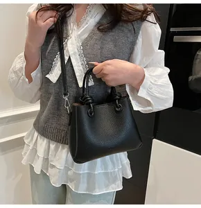 Detail of black lychee texture bucket bag with unique ring handle and knot design