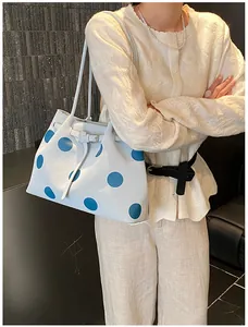Dettaglio della borsa tote azzurra a pois con fibbia in metallo e spalline sottili