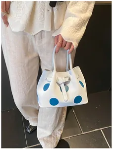 Dettaglio della borsa bianca a pois blu con fibbia in metallo argentato decorativo