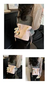Detail of pink quilted bucket bag with gold chain strap and decorative horse charm