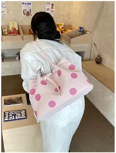 Dettaglio di una grande borsa tote rosa a pois con fibbia laterale e tracolla