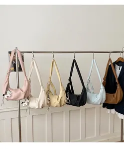 Row of colorful hobo bags with knot straps and decorative charms on a wall