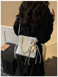 Detail of light blue quilted tote with gold chain and horse charm shown on model