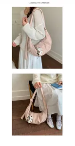 Detail of pink pleated half-moon bag with lychee texture and cute dog pendant