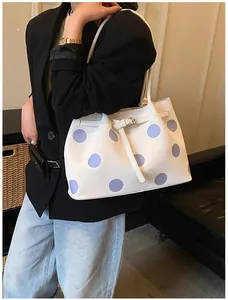 Dettaglio della borsa tote bianca in pelle PU a pois viola con fibbia su modella