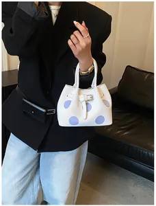 Dettaglio della borsa tote a pois con fibbia decorativa e motivo viola