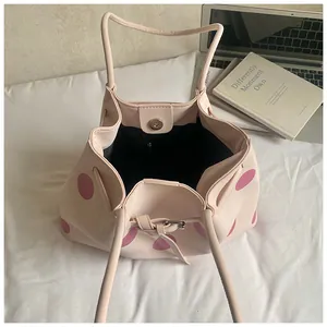 Dettaglio della borsa tote a pois rosa con chiusura a coulisse e fibbia magnetica