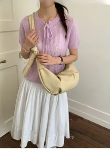 Chic beige croissant crescent bag with unique knotted strap detail shown on model