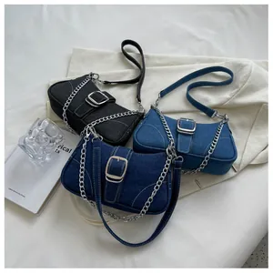 Dettaglio di borse a tracolla in denim nero, blu scuro e azzurro con fibbie in metallo