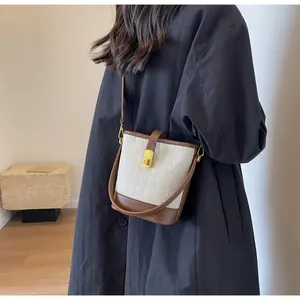 Vue détaillée du sac seau matelassé pour femmes en cuir contrasté marron et blanc
