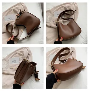 Detail view of coffee PU leather hobo bag with wide strap and cute bear charm decoration