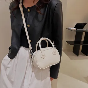 Dettaglio della borsa in pelle PU bianco crema testurizzata con outfit moderno