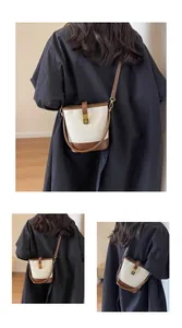 Détail du sac seau matelassé blanc avec bordure marron et fermoir doré en métal