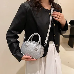 Dettaglio della mini borsa argento coccodrillo con giunti del manico a forma di cuore