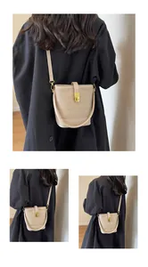 Détail du sac seau beige avec texture cuir matelassé et boucle en métal doré