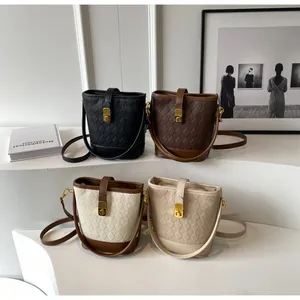 Détail de sacs seaux matelassés élégants en quatre couleurs sur des marches minimalistes