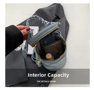 Internal capacity of light blue bucket bag with silk scarf showing phone and wallet