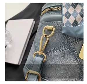 Detail showing blue denim leather bucket bag with gold hardware and silk scarf