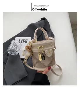 Detail of off-white bucket bag with silk scarf handle and plush monster charm