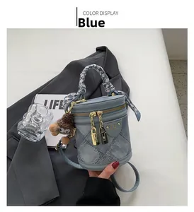 Blue denim bucket bag with scarf handle, gold hardware and plush monster charm detail