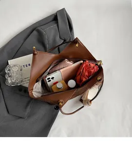 Interior view of brown leather tote bag showing large capacity for phone and umbrella