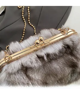 Gros plan sur le fermoir doré élégant et la texture en fausse fourrure du sac à bandoulière